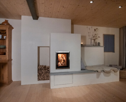 Lehmofen mit Dual-Feuerraum, (automatischer Pelletabbrand). Speicherofen mit natürlicher, wohliger Wärmeabgabe und entspannter Feuersicht. gebaut mit Liebe von wellflamm Feuer Manufaktur, Rapperswil, Schweiz