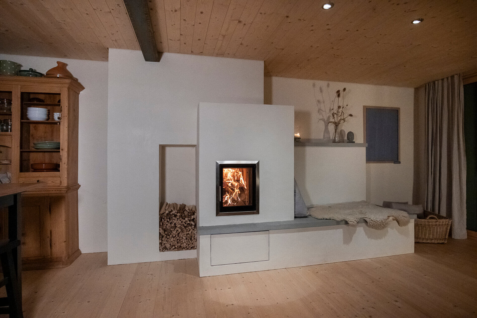 Lehmofen mit Dual-Feuerraum, (automatischer Pelletabbrand). Speicherofen mit natürlicher, wohliger Wärmeabgabe und entspannter Feuersicht. gebaut mit Liebe von wellflamm Feuer Manufaktur, Rapperswil, Schweiz